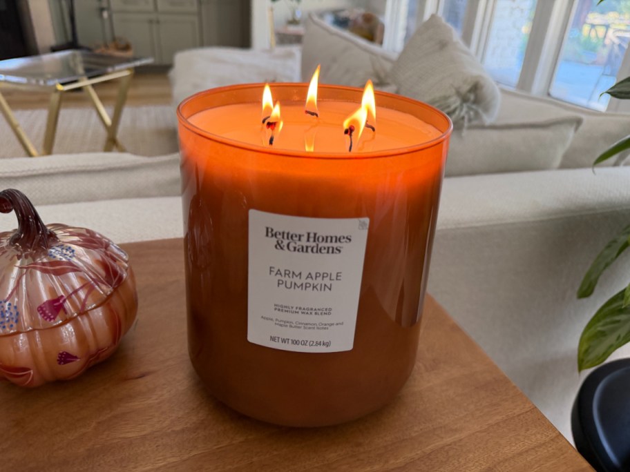 giant lit orange candle on a countertop