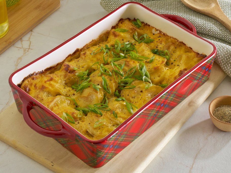 a red and green plaid stoneware baking dish with a casserole in it