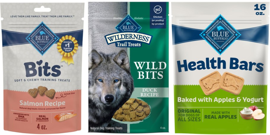 Three packages of Blue Buffalo dog treats featuring Bits salmon recipe, Wilderness Wild Bits duck recipe with a wolf illustration, and Health Bars baked with apples and yogurt.