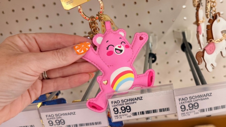womans hand holding a cheer bear bag charm