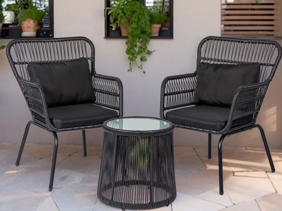 wicker chair and center table set in black with cushion displayed outside 