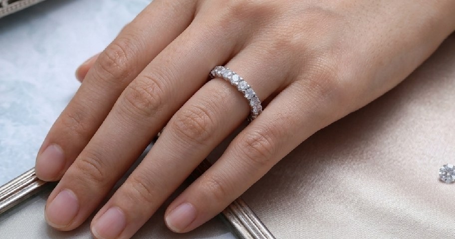 woman's hand with a silver wedding band