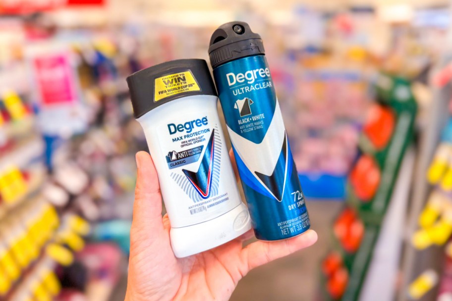 hand holding deodorant stick and spray in store