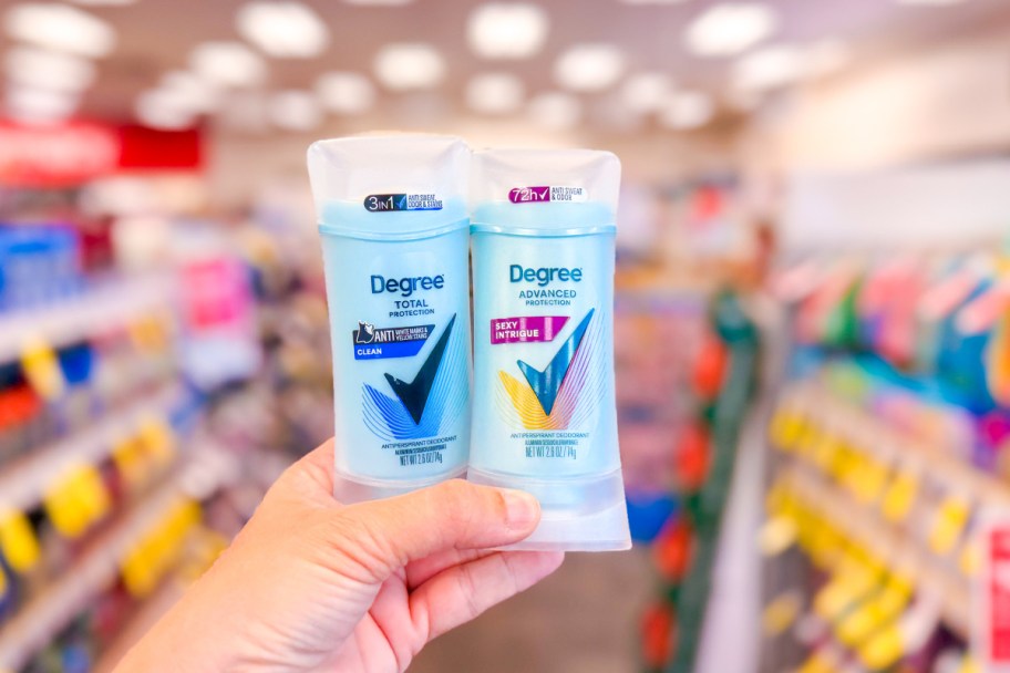 hand holding two blue deodorant sticks