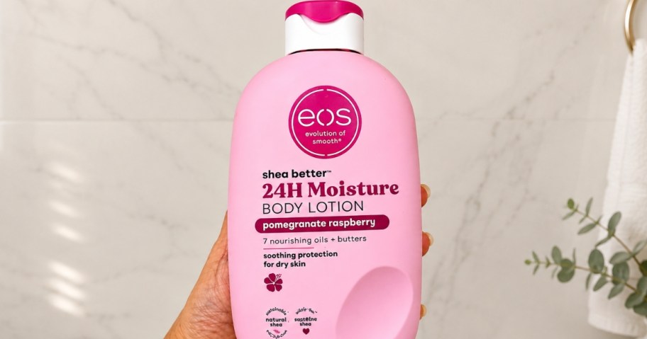 hand holding a bottle of eos body lotion