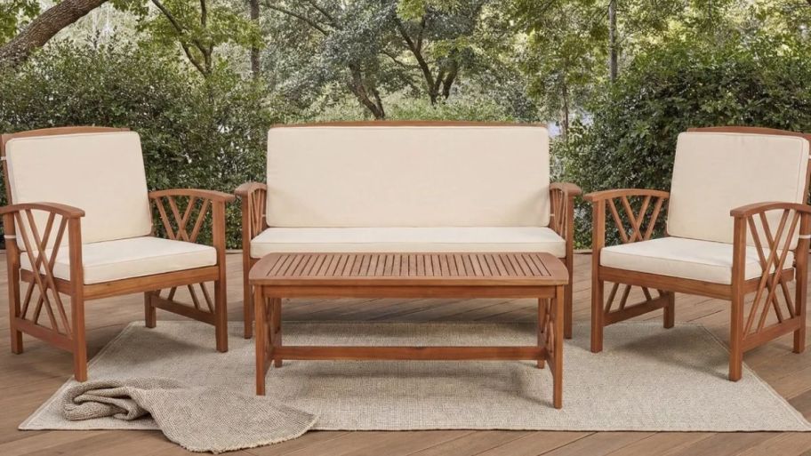 four-piece outdoor seating with beige cushions and a table