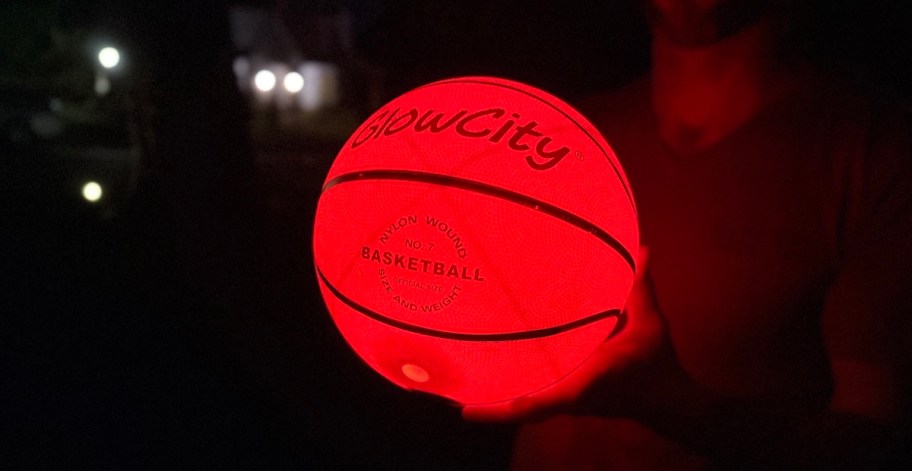 man holding glow in the dark glow city basketball