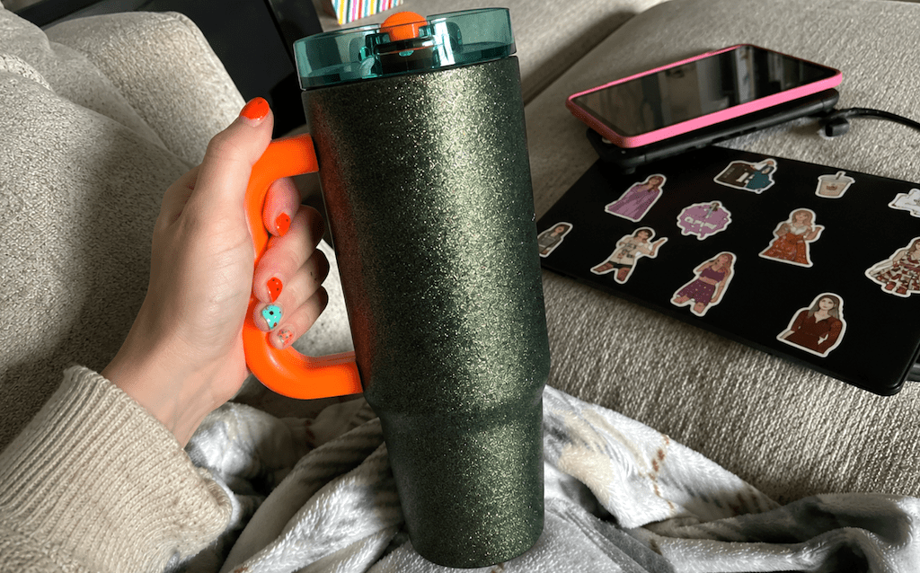 holding green glitter tumbler