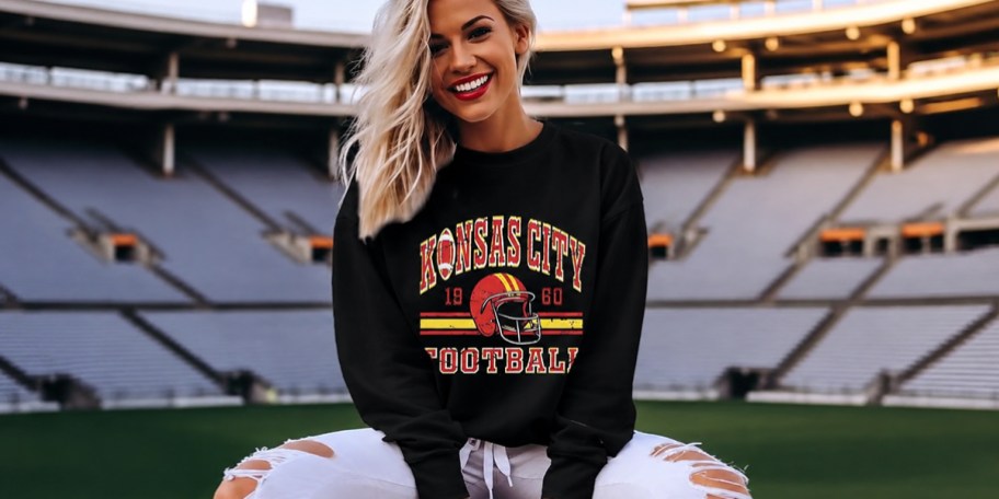 blonde woman wearing black kansas city sweatshirt
