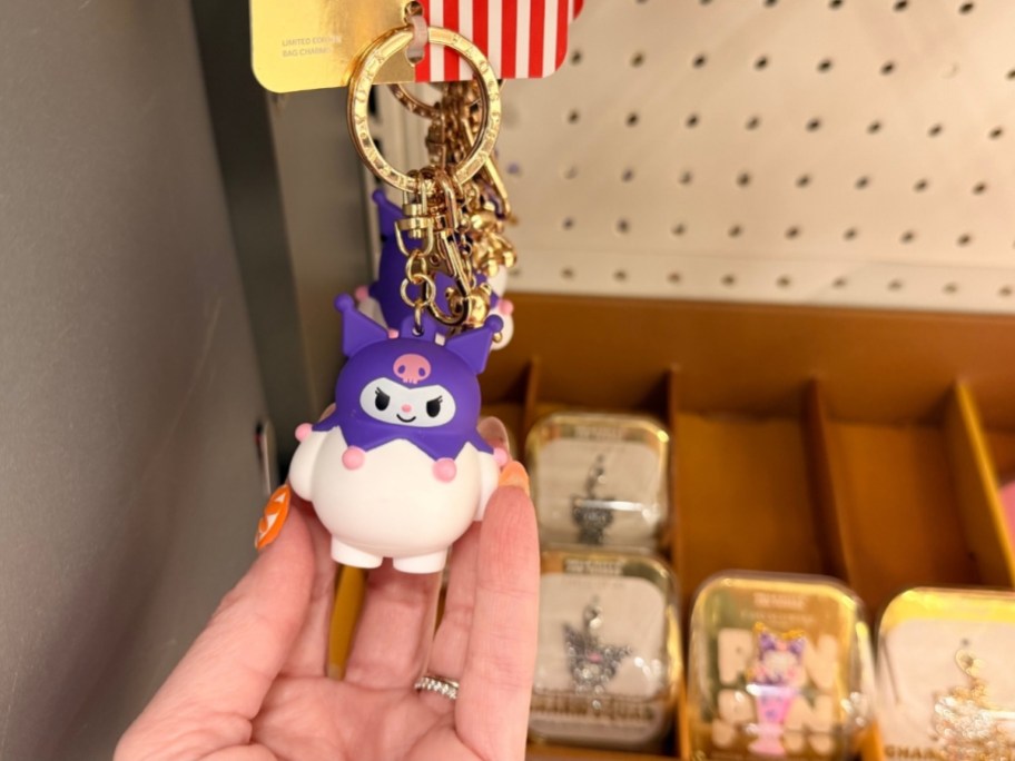 womans hand holding a kuromi bag charm