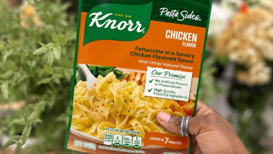 womans hand holding a package of chicken fettucine pasta