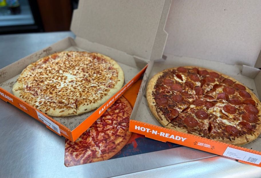 two little caesars pizzas in boxes on counter