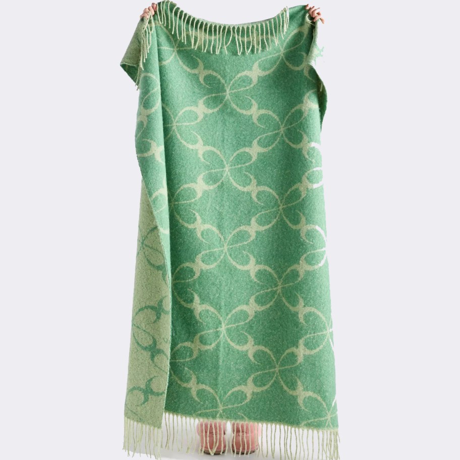 woman holding green throw blanket 