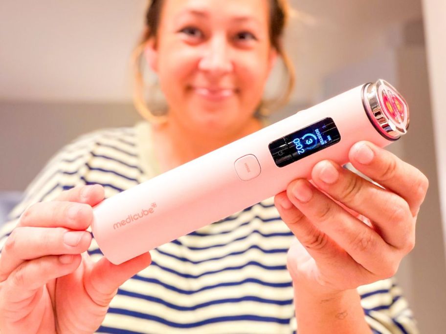 Woman holding a medicube Booster Pro X2 - 7 in 1 Glow Beauty Device