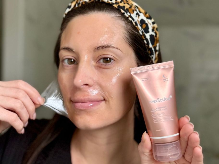 woman peeling a medicube Wrapping Mask Collagen - Overnight Peel-Off Facial Mask off her face