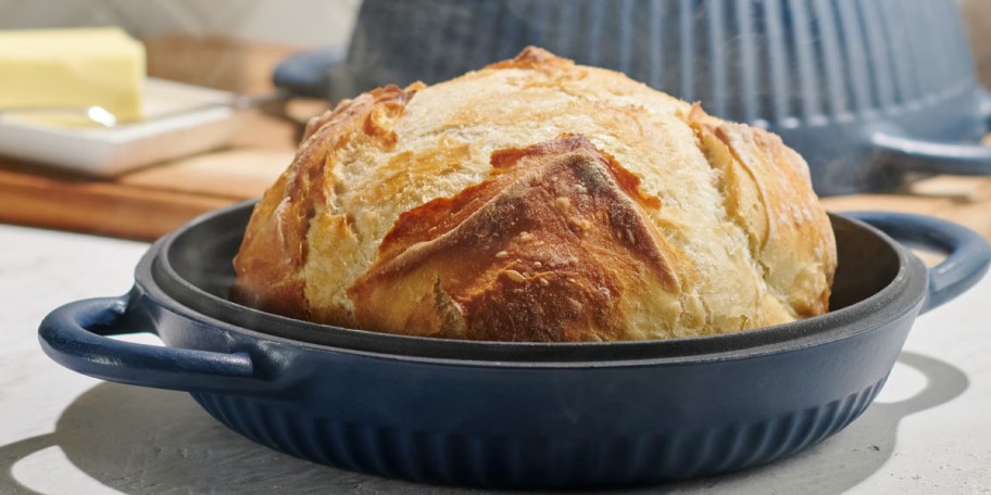 blue dutch oven with bread on top on counter 