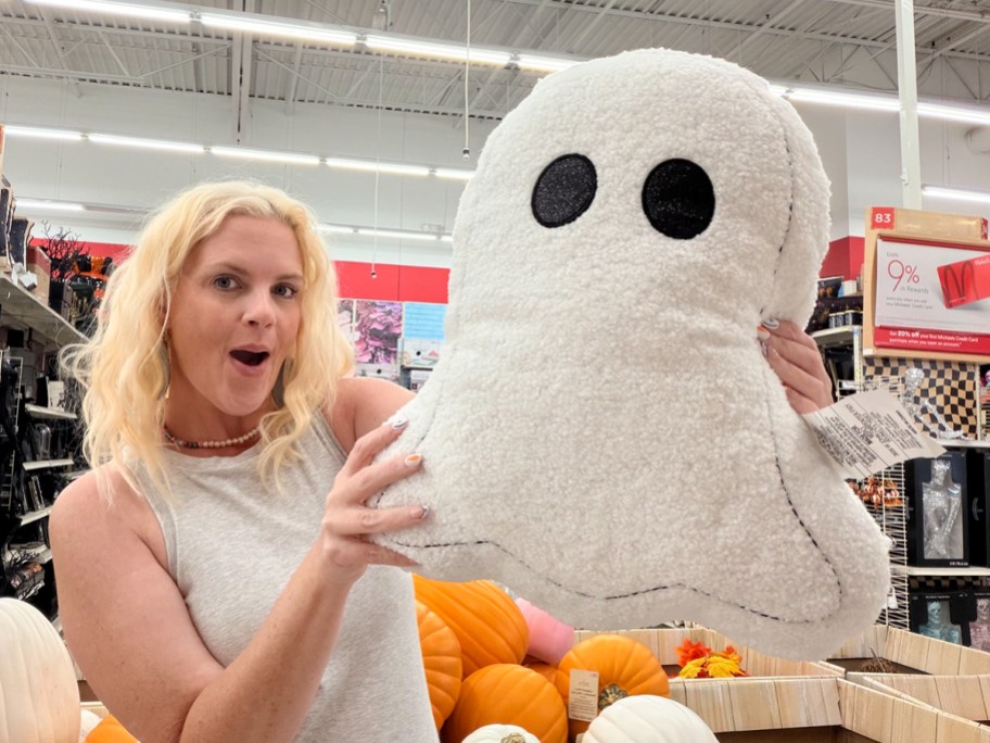 woman holding white ghost pillow