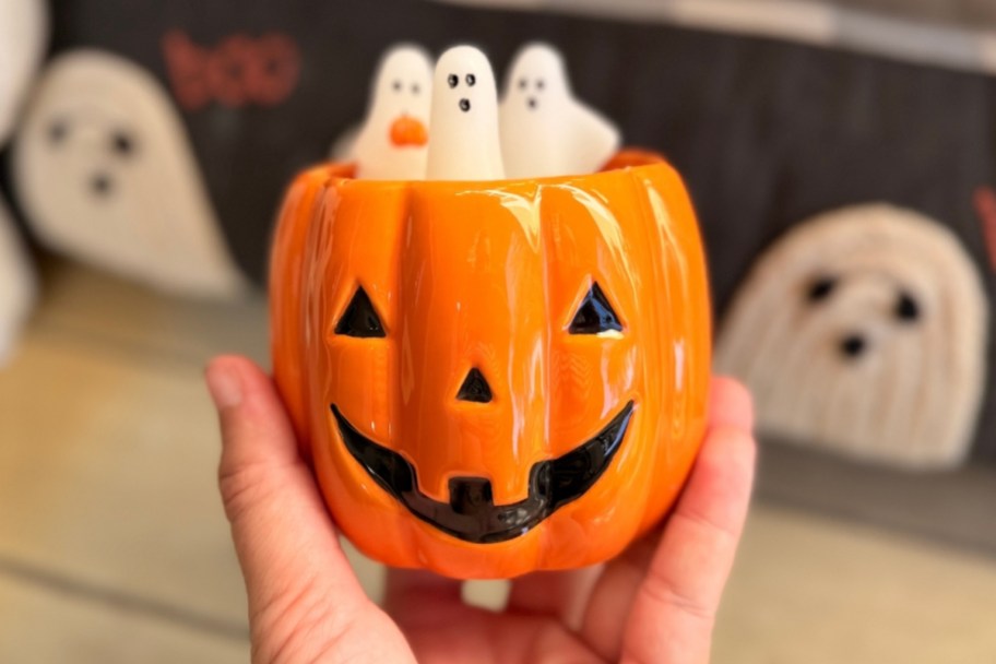 hand holding a jack o lantern figural candle