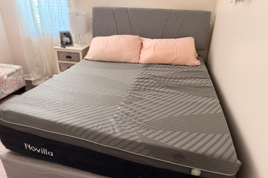 grey mattress with two pink pillows