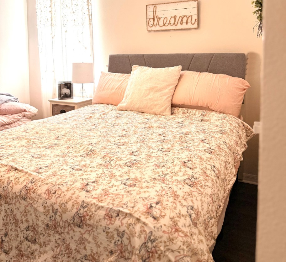 floral bedding with two pink pillows and grey headboard