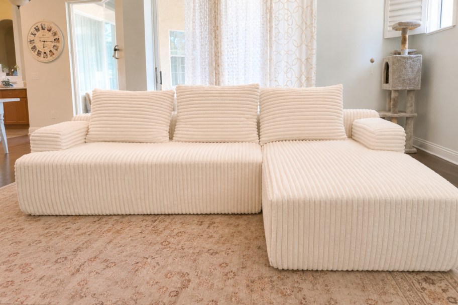 small white sectional sofa with thtree pillows