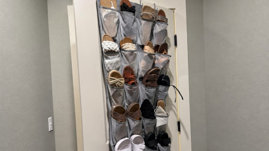 shoe rack on the back of a door, filled with various types of shoes