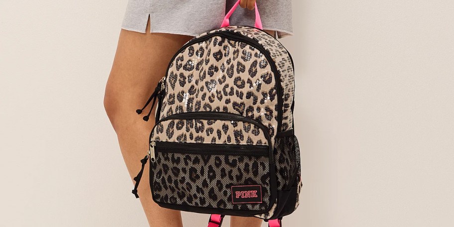 person holding leopard print backpack
