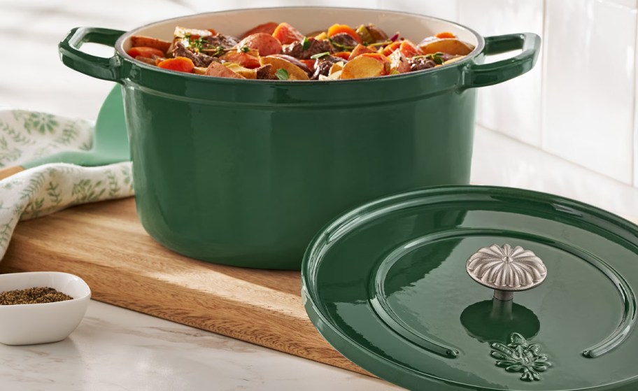 green dutch oven on cutting board with food inside 