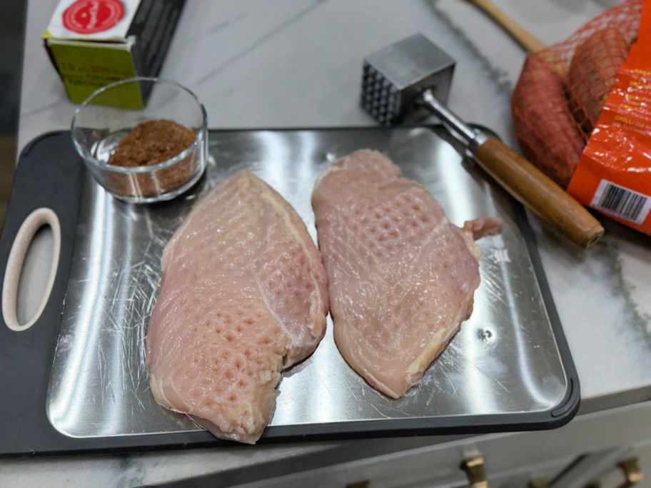 pounded chicken on a cutting board 
