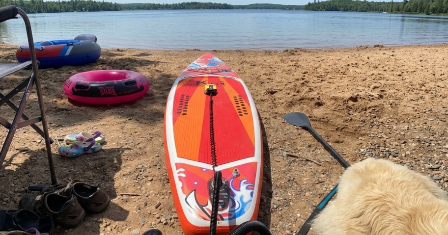 orange paddleboard on beach at lake