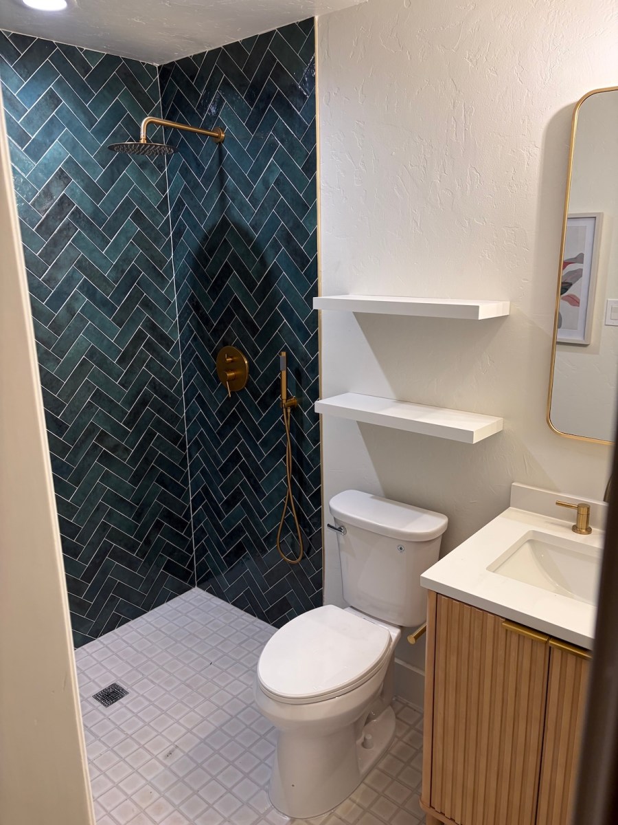 bathroom with green herringbone shower and vanity