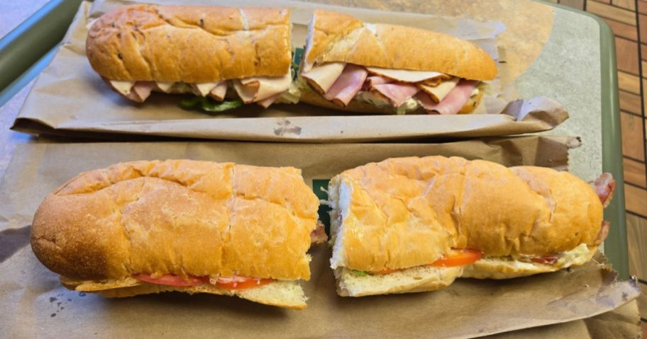 two subway footlong sandwiches on table