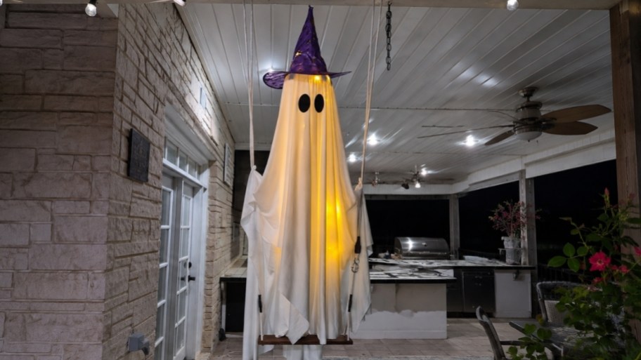 swinging light up ghost decor hanging on a porch