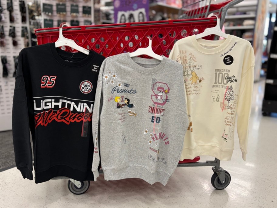 3 sweatshirts hanging on a target cart