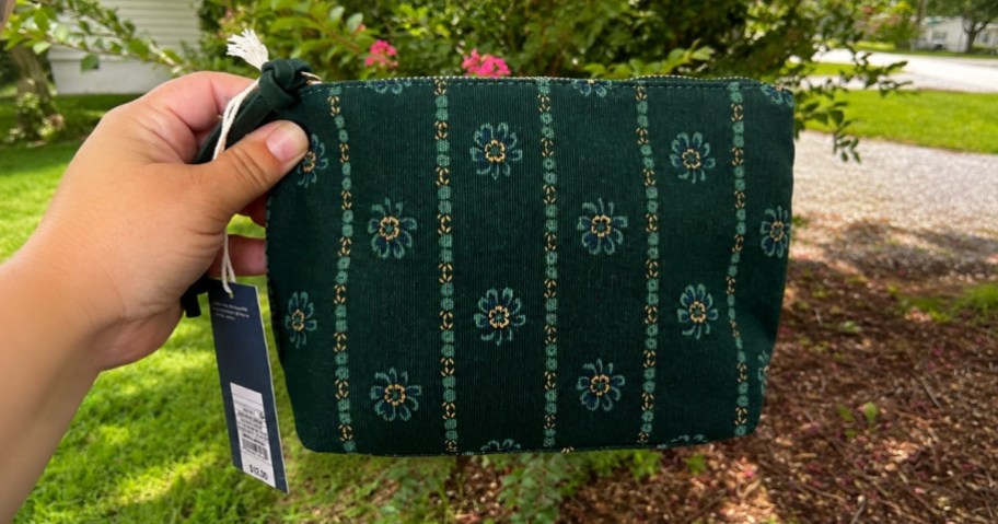 hand holding a green floral zipper pouch