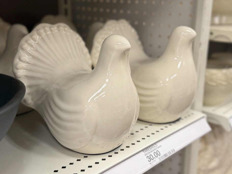 two white ceramic turkeys on shelf 