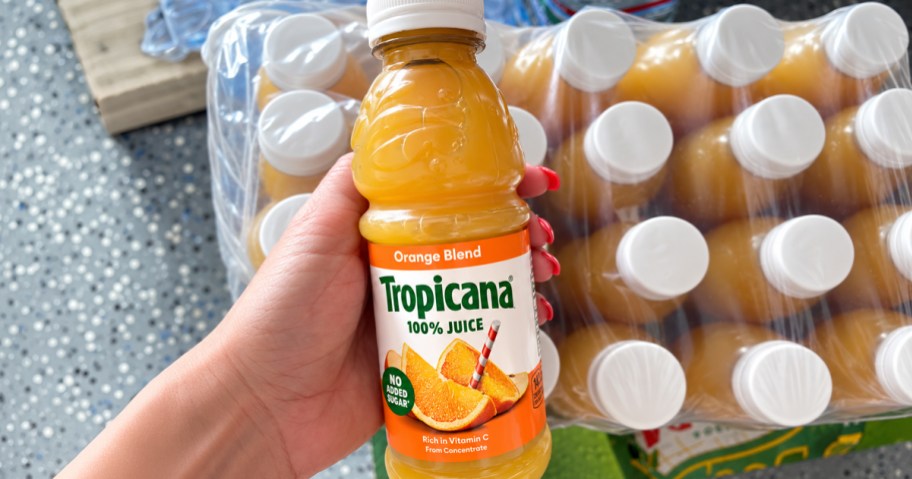 hand holding a bottle of orange juice