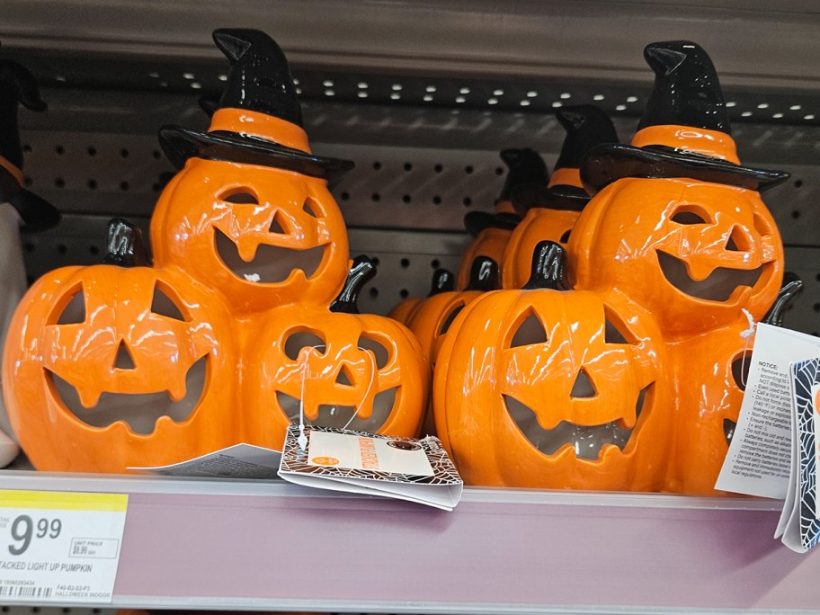two ceramic pumpkin figures on shelf 