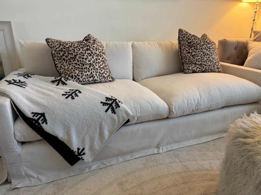 beige sofa with cheetah throw pillows and black and white throw blanket