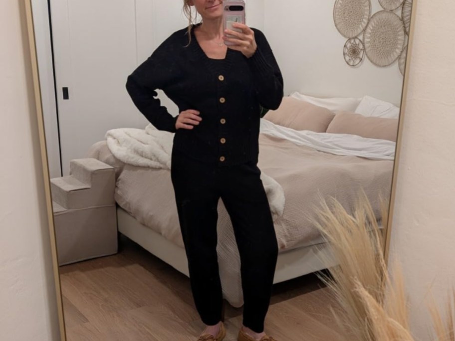 a woman in a black 2 piece cardigan set taking a selfie