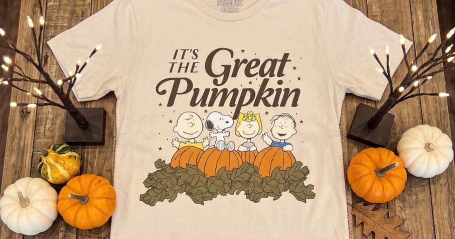 Adult It's The Great Pumpkin Graphic Tee on fall-themed table
