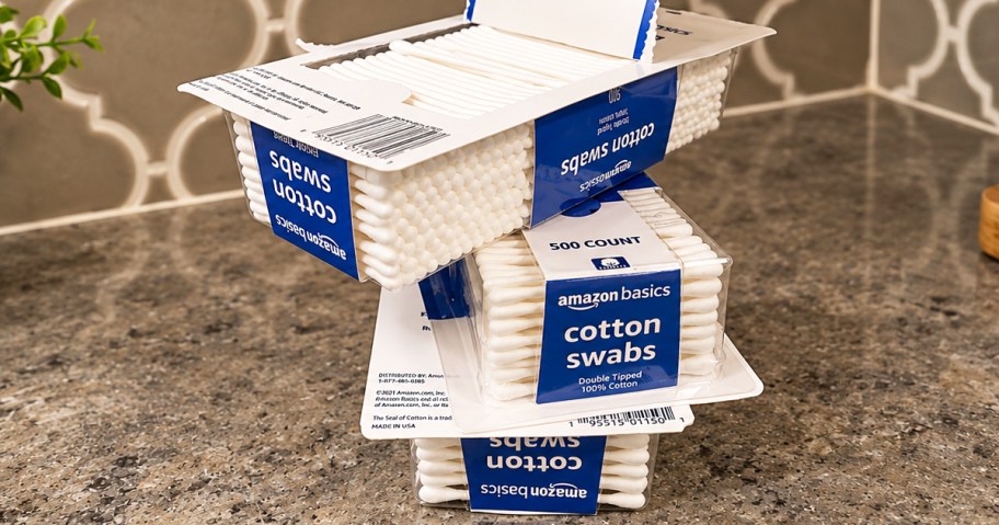 three stacked boxes of Amazon Basics Cotton Swabs