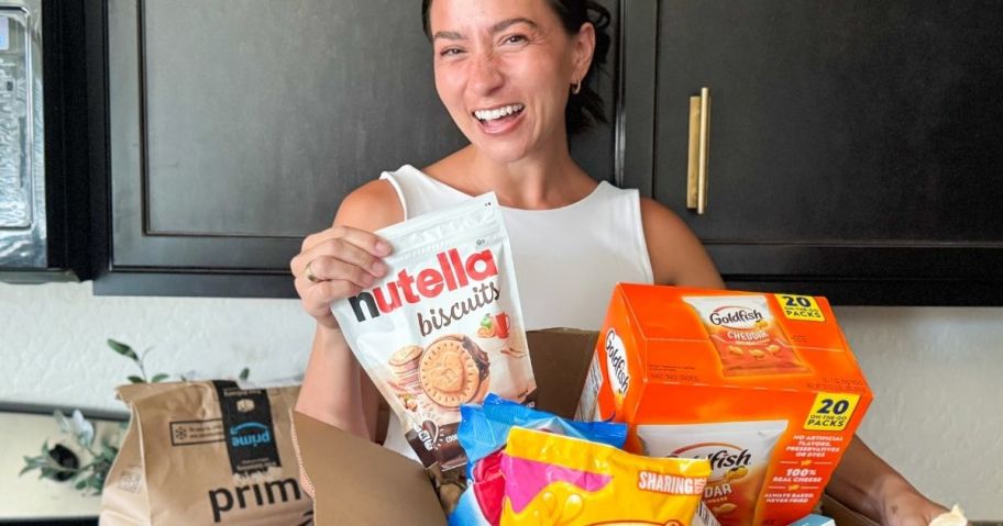 woman holding a bag of Nutella Cookies with a box of grocery items from amazon