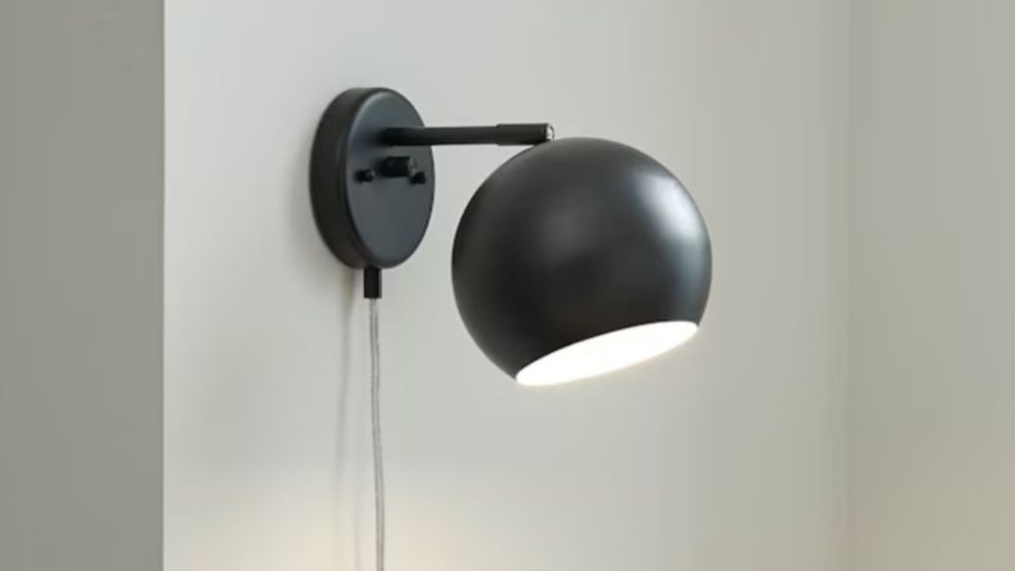 Black wall scone displayed on a gray wall