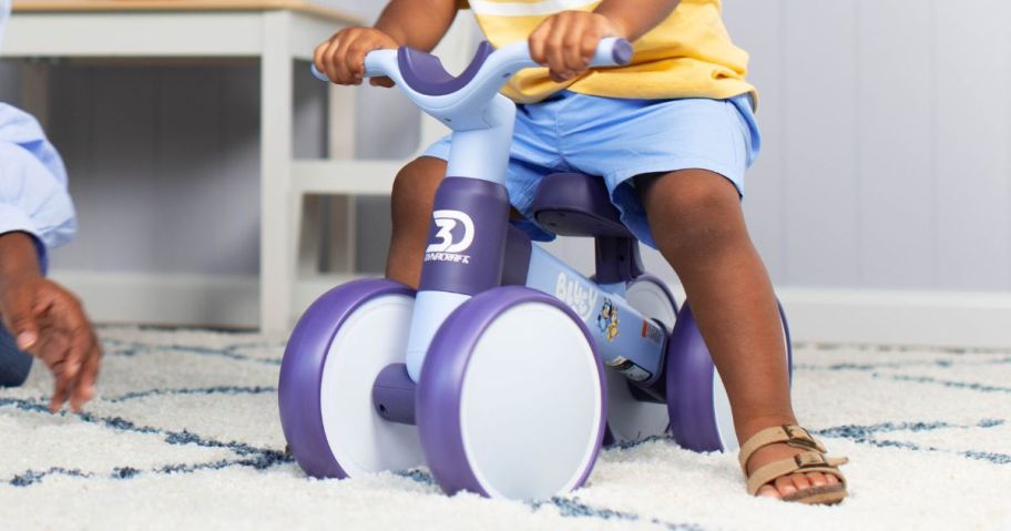 kid sitting on Bluey Toddler 4-Wheel Balance Bike