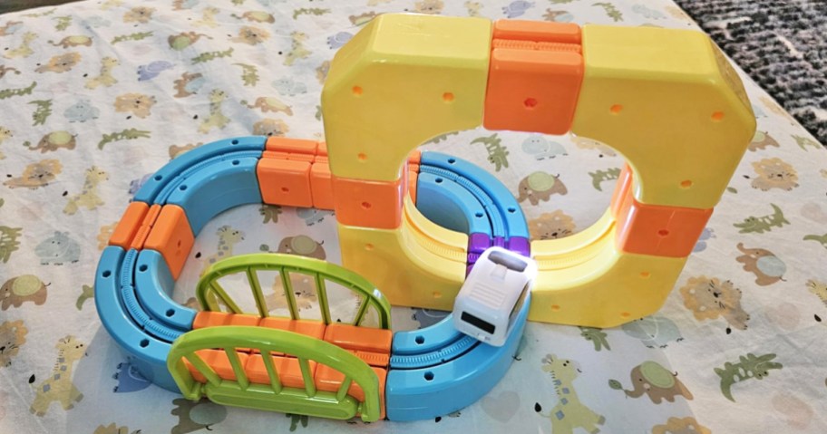 colorful kids train track set on top of a baby blanket