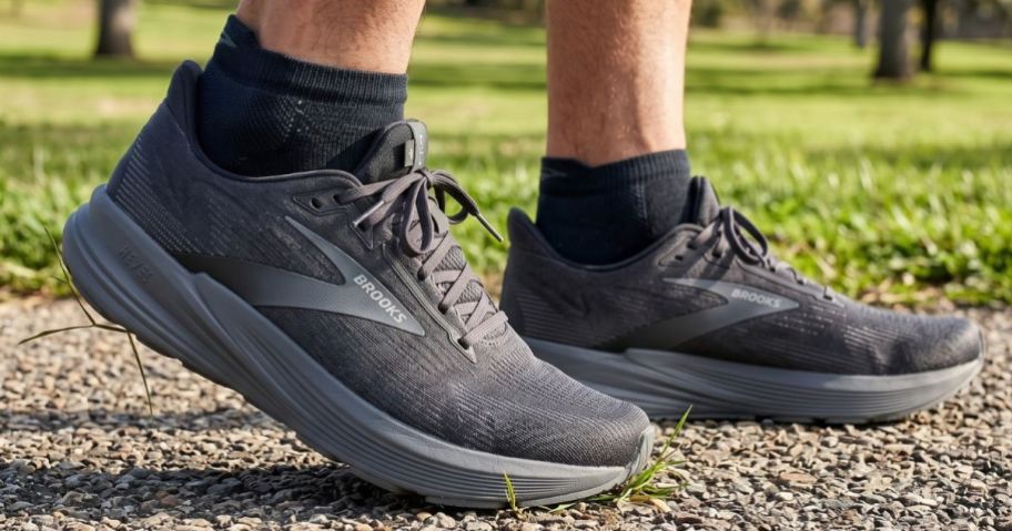 Man's feet wearing black Brooks Men's Revel running shoes