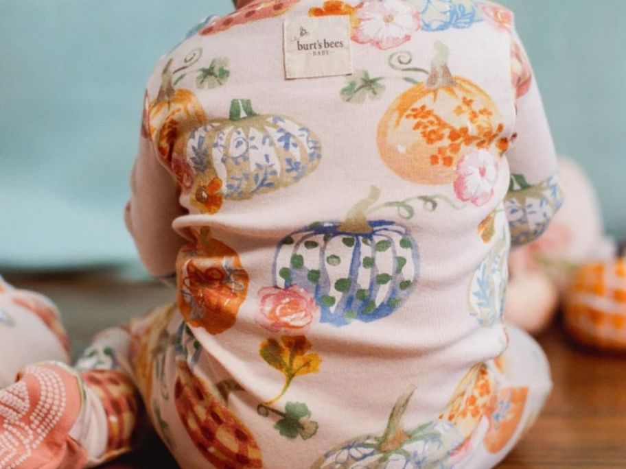 Baby wearing Burt Bees footie pumpkin pajamas
