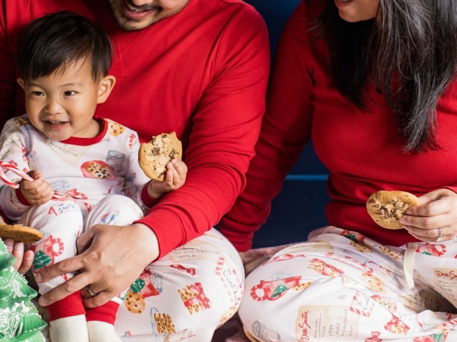 couple wearing christmas pajamas and a baby