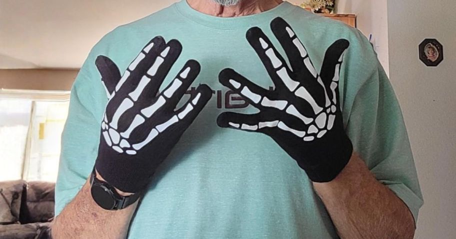 man's hands wearing gloves with skeleton print on them